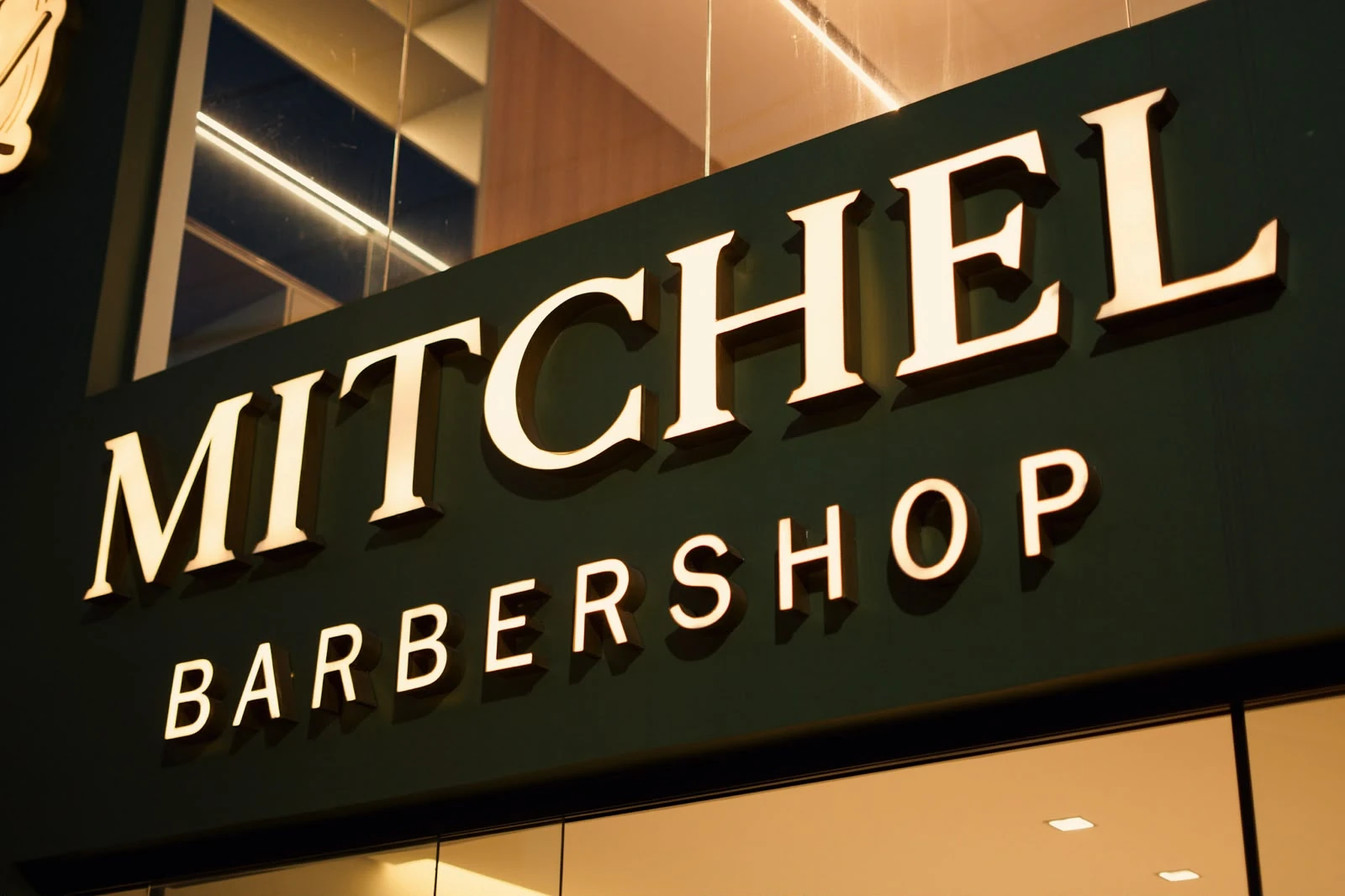 Fachada da Mitchel Barbershop, com letreiro iluminado